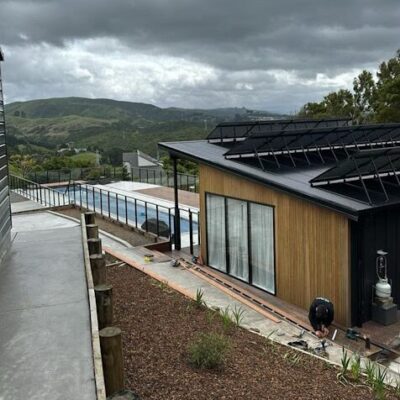 Side elevation of timber pool house with hill views and landscaped surrounds constructed by Total Build Wellington.