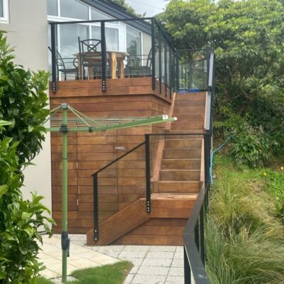A timber outdoor staircase and deck with glass balustrades, showcasing smart small house design extensions, modern house designs, and home builder craftsmanship used in new houses and design and build projects.