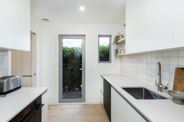 A modern scullery with generous bench space, clean white finishes, and exterior access, reflecting thoughtful home construction and design builders’ attention to detail in new houses and build a home projects.
