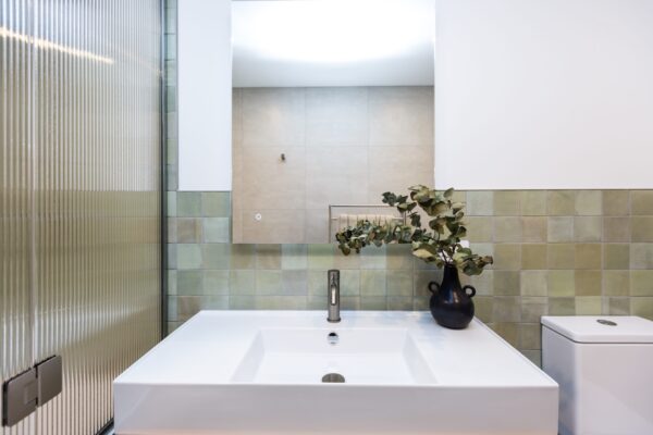 A clean modern vanity and tile feature wall in a new build bathroom, demonstrating high-quality design builders’ work and thoughtful house plans for architectural builds and design and build projects.