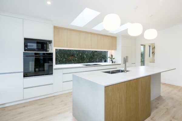 A modern kitchen with skylights, pendant lighting, and well-designed storage, demonstrating quality home construction and design and build expertise for new builds and architecturally designed homes.